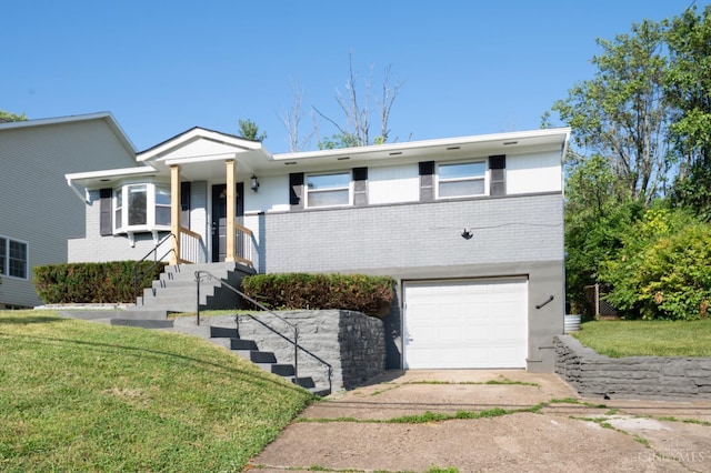 8784 Pippin Rd, Colerain Twp, OH 45251 - view of front of house with a garage, brick siding, driveway, and a front lawn