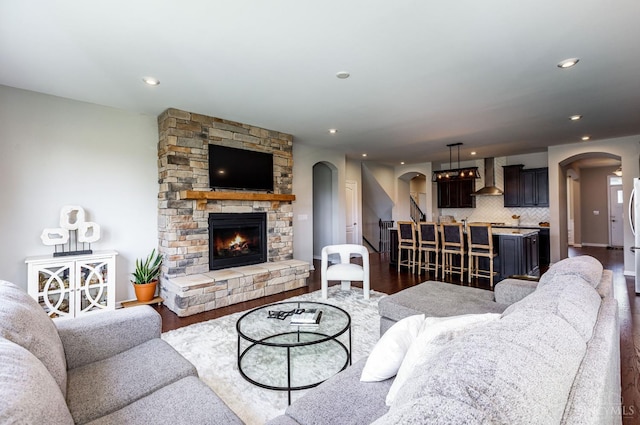 3779 Sturbridge Way, Pierce Twp, OH 45245 - living area with arched walkways, dark wood-type flooring, a stone fireplace, and recessed lighting