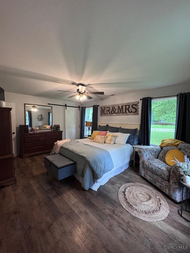 9063 Morrow Woodville Rd, Harlan Twp, OH 45162 - bedroom with wood finished floors, ceiling fan, and a barn door