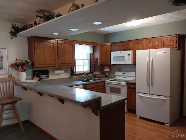 13353 State Route 28 W, Greenfield, OH 45123 - kitchen featuring white appliances, a peninsula, brown cabinetry, and recessed lighting