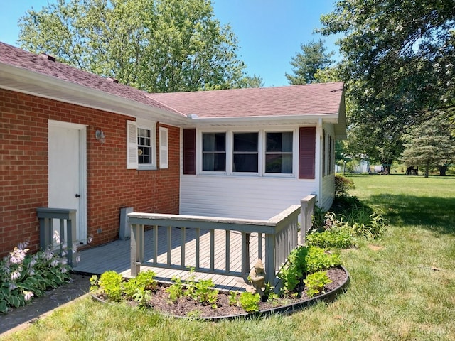 13353 State Route 28 W, Greenfield, OH 45123 - view of exterior entry with a wooden deck, a yard, brick siding, and roof with shingles