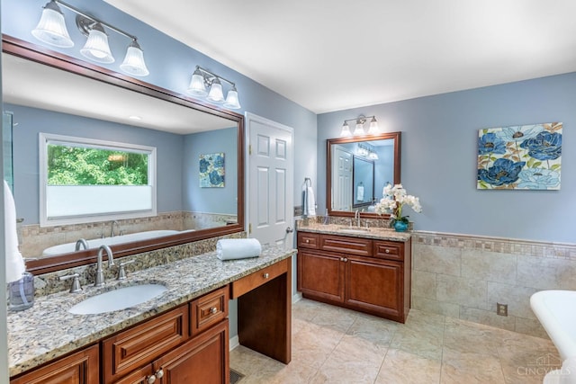8551 Trillium Ridge Ln, Anderson Twp, OH 45255 - bathroom with a soaking tub, vanity, a wainscoted wall, tile walls, and tile patterned floors
