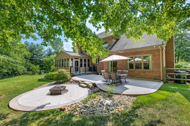 8551 Trillium Ridge Ln, Anderson Twp, OH 45255 - back of house with an outdoor fire pit, a patio area, brick siding, a sunroom, and a lawn