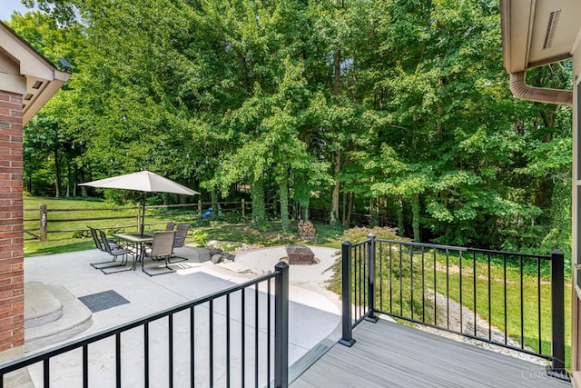 8551 Trillium Ridge Ln, Anderson Twp, OH 45255 - wooden deck with a fire pit, a patio, a fenced backyard, outdoor dining space, and view of scattered trees