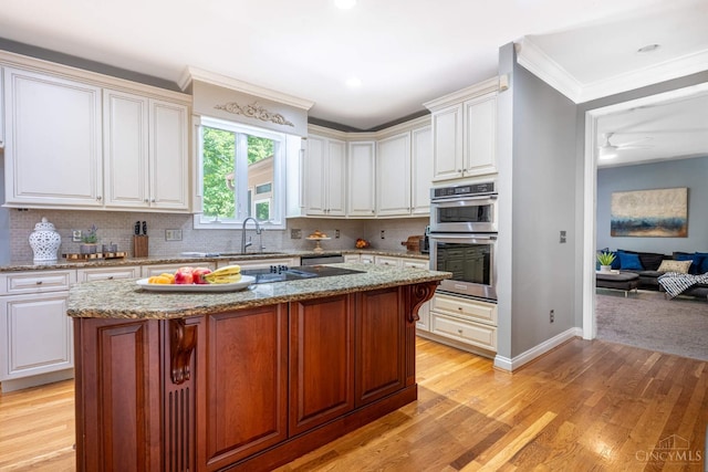 8551 Trillium Ridge Ln, Anderson Twp, OH 45255 - kitchen featuring stainless steel double oven, crown molding, tasteful backsplash, light stone counters, and white cabinets