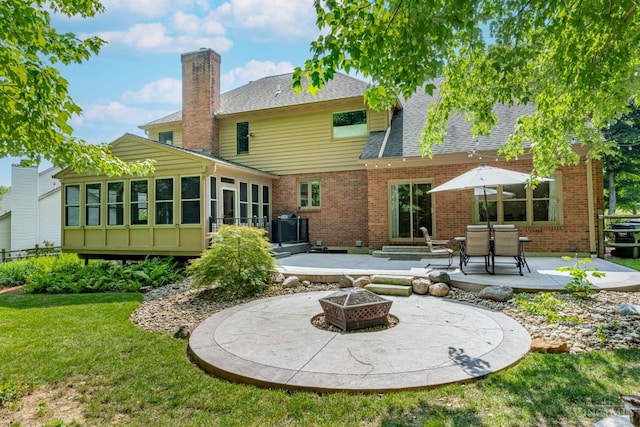 8551 Trillium Ridge Ln, Anderson Twp, OH 45255 - rear view of house with a chimney, a patio, a fire pit, a sunroom, and brick siding