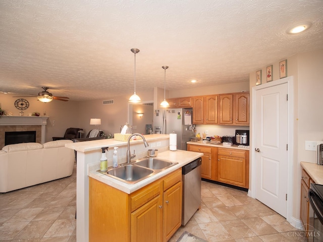 7854 Cape Cod Ct, West Chester, OH 45069 - kitchen featuring appliances with stainless steel finishes, open floor plan, light countertops, ceiling fan, and a center island with sink