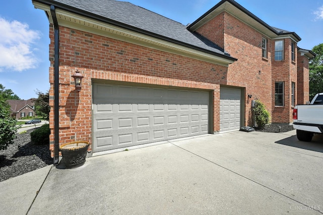 7066 Hearthside Ct, Liberty Twp, OH 45011 - view of side of property with brick siding, concrete driveway, an attached garage, and a shingled roof