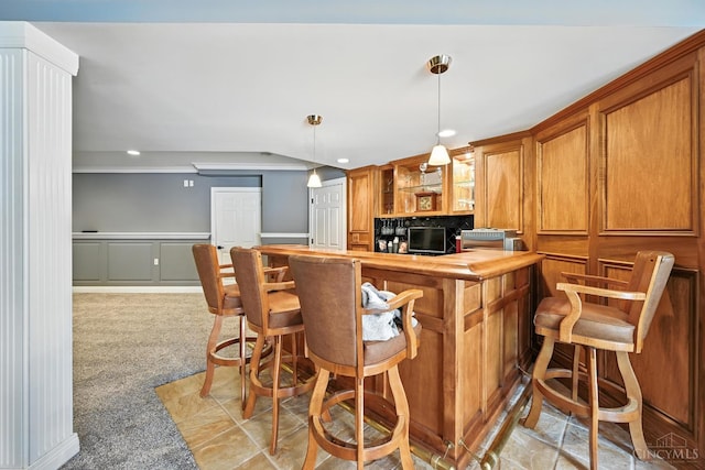7066 Hearthside Ct, Liberty Twp, OH 45011 - kitchen featuring brown cabinetry, recessed lighting, decorative light fixtures, glass insert cabinets, and light colored carpet