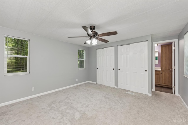 14697 Bodman Rd, Sterling Twp, OH 45154 - unfurnished bedroom with carpet floors, two closets, ensuite bath, and a ceiling fan