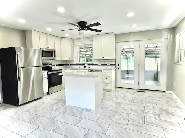 5424 Delhi Rd, Delhi Twp, OH 45238 - kitchen with stainless steel appliances, light countertops, light marble finish floors, white cabinets, and a ceiling fan