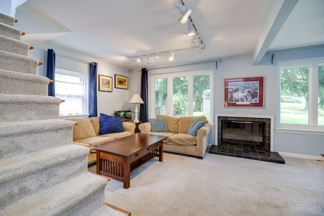 8012 Euclid Ave, Madeira, OH 45243 - carpeted living room featuring stairway, plenty of natural light, rail lighting, and a tile fireplace