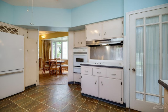 8012 Euclid Ave, Madeira, OH 45243 - kitchen featuring white appliances, under cabinet range hood, a warming drawer, white cabinets, and dark countertops