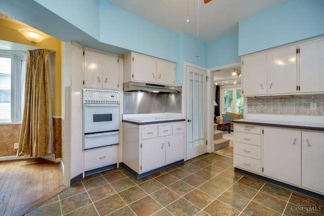 8012 Euclid Ave, Madeira, OH 45243 - kitchen featuring oven, a warming drawer, under cabinet range hood, and white cabinetry
