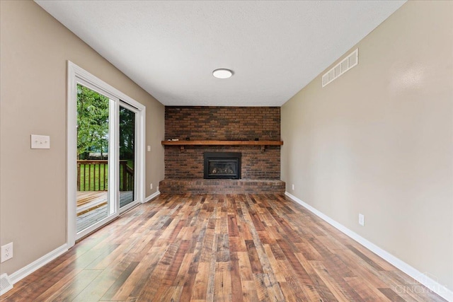 2535 Crane Schoolhouse Rd, Tate Twp, OH 45106 - unfurnished living room with hardwood / wood-style floors and a brick fireplace