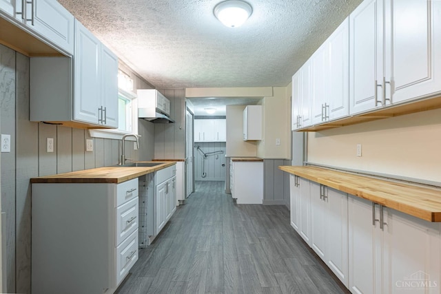 989 E Ogden Rd, Adams Twp, OH 45177 - kitchen with butcher block countertops, a textured ceiling, wood finished floors, and white cabinetry