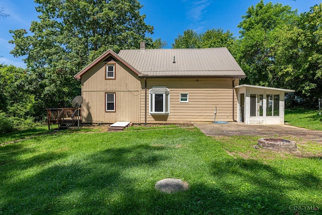 989 E Ogden Rd, Adams Twp, OH 45177 - back of property with a fire pit, a sunroom, a wooden deck, and a yard