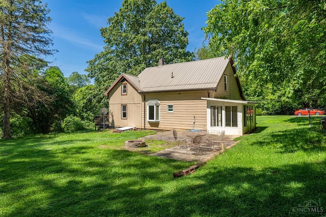 989 E Ogden Rd, Adams Twp, OH 45177 - back of property featuring a patio, a yard, a fire pit, a metal roof, and a chimney
