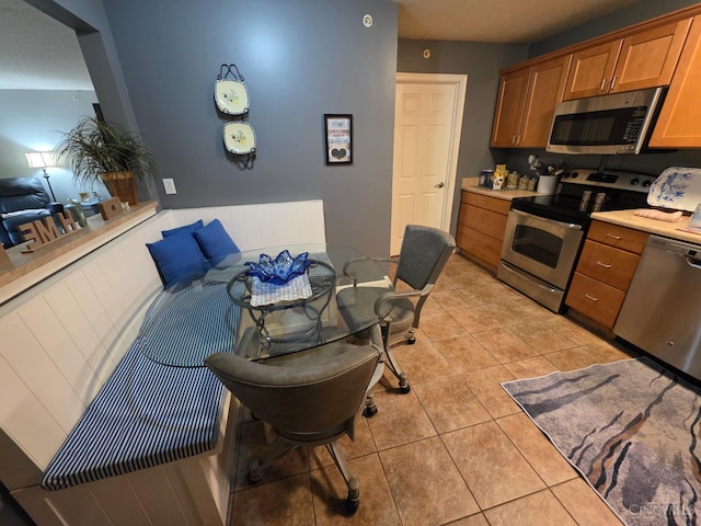 311 Miami Trce Unit 5, Harrison, OH 45030 - kitchen featuring stainless steel appliances, light countertops, brown cabinetry, and light tile patterned floors