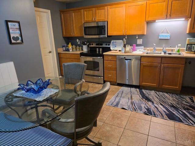 311 Miami Trce Unit 5, Harrison, OH 45030 - kitchen with appliances with stainless steel finishes, light countertops, light tile patterned floors, and brown cabinetry