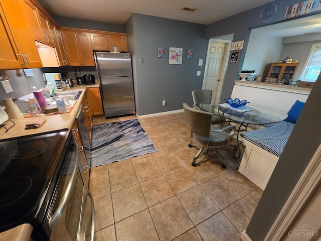311 Miami Trce Unit 5, Harrison, OH 45030 - kitchen with appliances with stainless steel finishes, light countertops, brown cabinetry, and light tile patterned flooring