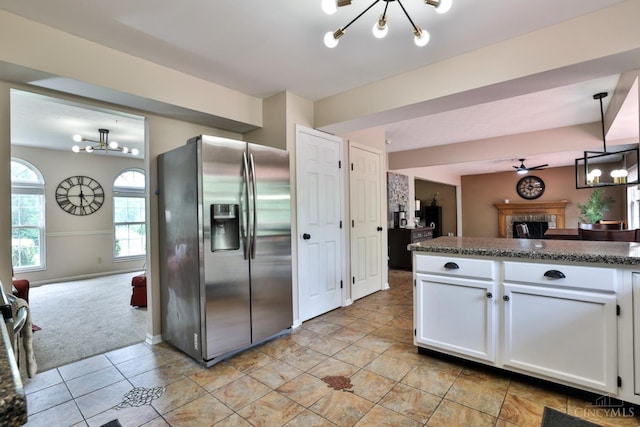6330 Branch Hill Miamiville Rd, Miami Twp, OH 45140 - kitchen featuring stainless steel fridge with ice dispenser, a chandelier, a fireplace, and white cabinets