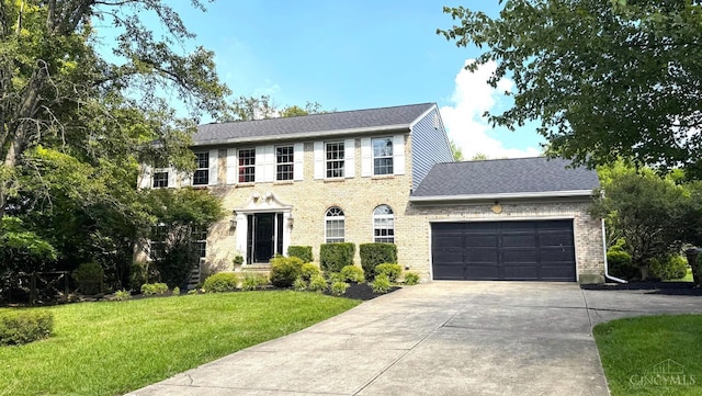 6330 Branch Hill Miamiville Rd, Miami Twp, OH 45140 - colonial home featuring a front yard, a garage, concrete driveway, and brick siding