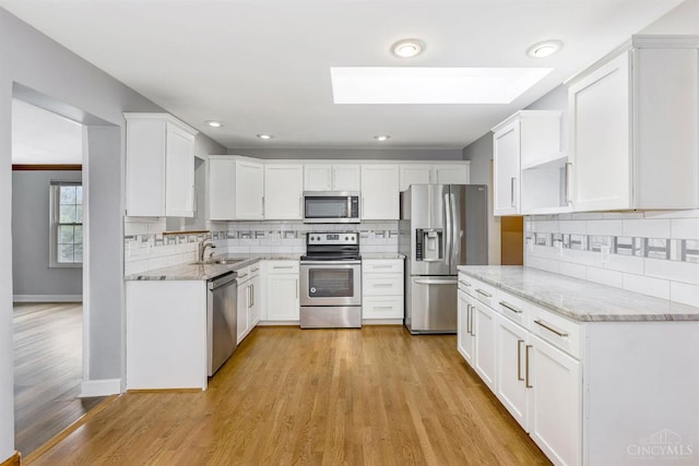 3324 Moonridge Dr, Green Twp, OH 45248 - kitchen with stainless steel appliances, a skylight, tasteful backsplash, light wood-style floors, and recessed lighting