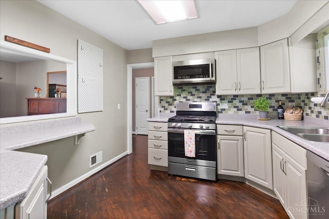 281 Compton Rd, Wyoming, OH 45215 - kitchen featuring stainless steel appliances, tasteful backsplash, dark wood-type flooring, light countertops, and white cabinets