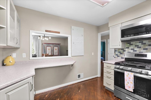 281 Compton Rd, Wyoming, OH 45215 - kitchen with appliances with stainless steel finishes, light countertops, backsplash, white cabinets, and dark wood-type flooring