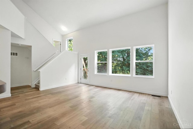 2380 Oaktree Pl, Cincinnati, OH 45238 - unfurnished living room with healthy amount of natural light, stairway, a high ceiling, and light wood-style floors