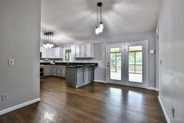 6154 Taylor Pike, Wayne Twp, OH 45107 - kitchen with dark countertops, range with two ovens, a textured ceiling, a peninsula, and pendant lighting