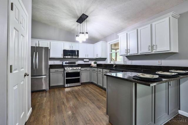 6154 Taylor Pike, Wayne Twp, OH 45107 - kitchen featuring stainless steel appliances, a peninsula, dark wood-style floors, hanging light fixtures, and white cabinets