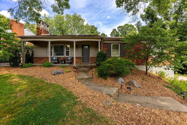 1050 Holz Ave, Anderson Twp, OH 45230 - ranch-style home with covered porch, a chimney, brick siding, and a front lawn