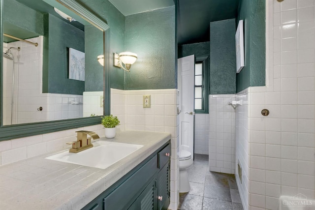 1050 Holz Ave, Anderson Twp, OH 45230 - bathroom featuring tile walls, vanity, a textured wall, stone tile flooring, and wainscoting