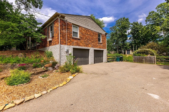 1050 Holz Ave, Anderson Twp, OH 45230 - view of home's exterior featuring a garage, driveway, and brick siding