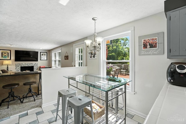 4961 Troubador Ct, Delhi Twp, OH 45238 - dining space with a chandelier, a textured ceiling, and a tile fireplace