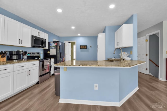 4411 Todd Rose Ct, Union Twp, OH 45244 - kitchen with black appliances, light wood-style floors, white cabinets, light stone countertops, and recessed lighting