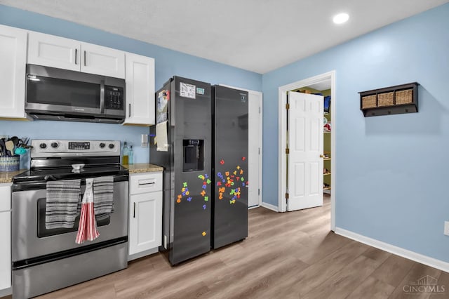4411 Todd Rose Ct, Union Twp, OH 45244 - kitchen featuring appliances with stainless steel finishes, white cabinets, light wood-type flooring, light stone countertops, and recessed lighting