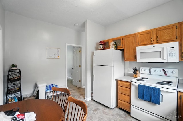 3254 Berwyn Pl, Cincinnati, OH 45209 - kitchen featuring white appliances, light countertops, brown cabinetry, and light tile patterned floors