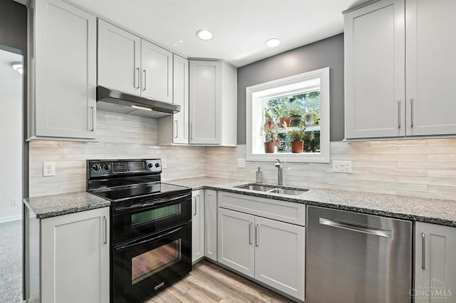 7102 Lookout Ct, Liberty Twp, OH 45011 - kitchen with stainless steel dishwasher, double oven range, under cabinet range hood, light stone countertops, and recessed lighting