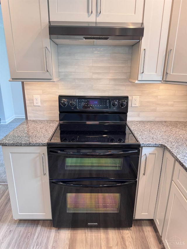 7102 Lookout Ct, Liberty Twp, OH 45011 - kitchen featuring range with two ovens, exhaust hood, tasteful backsplash, and light stone countertops