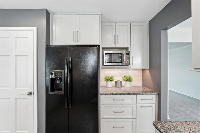 7102 Lookout Ct, Liberty Twp, OH 45011 - kitchen featuring black fridge with ice dispenser, stainless steel microwave, light stone countertops, and white cabinetry