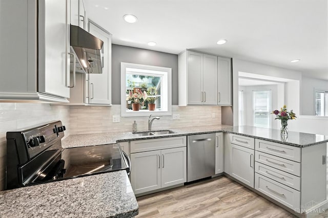 7102 Lookout Ct, Liberty Twp, OH 45011 - kitchen with black range with electric stovetop, stainless steel dishwasher, range hood, a peninsula, and light stone counters