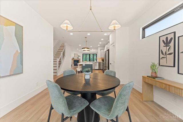 963 Windsor St, Cincinnati, OH 45206 - dining space featuring recessed lighting, light wood-style floors, and a glass covered fireplace