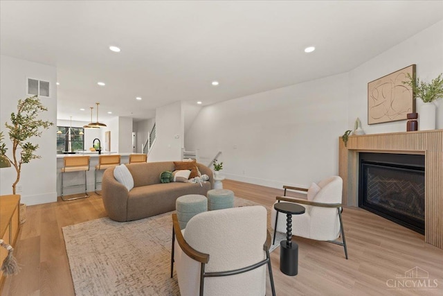 963 Windsor St, Cincinnati, OH 45206 - living room featuring light wood-style floors, recessed lighting, and a glass covered fireplace