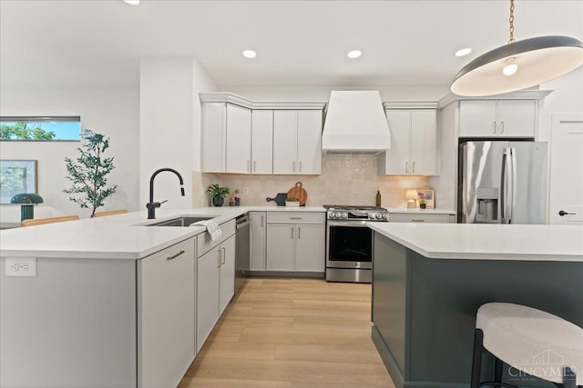 963 Windsor St, Cincinnati, OH 45206 - kitchen with stainless steel appliances, custom range hood, a peninsula, light countertops, and tasteful backsplash