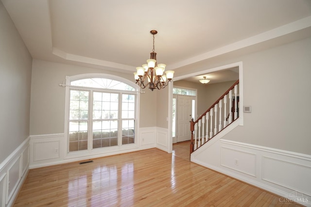 1031 Westchester, Union Twp, OH 45244 - empty room featuring a chandelier, a decorative wall, light wood-style flooring, a wainscoted wall, and stairway