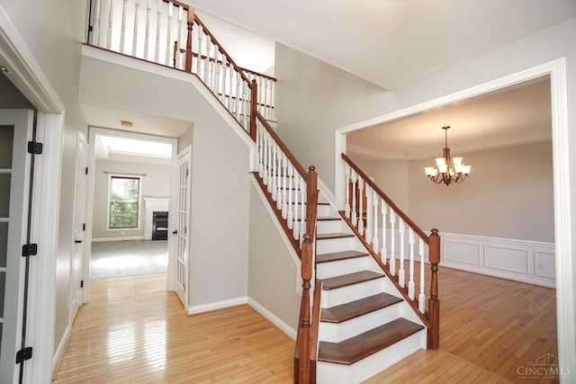 1031 Westchester, Union Twp, OH 45244 - stairway with hardwood / wood-style flooring, a chandelier, and a fireplace