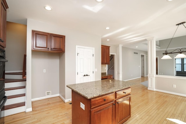 1031 Westchester, Union Twp, OH 45244 - kitchen featuring light wood-style floors, light stone countertops, recessed lighting, ornate columns, and a kitchen island